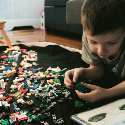 A young boy playing with LEGO