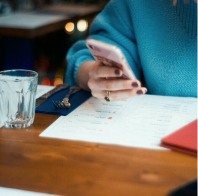 A woman looking at work emails while having dinner