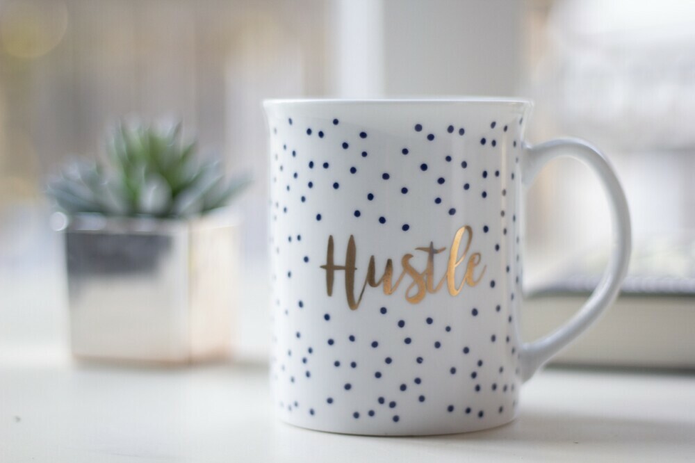 a mug that says hustle on the side