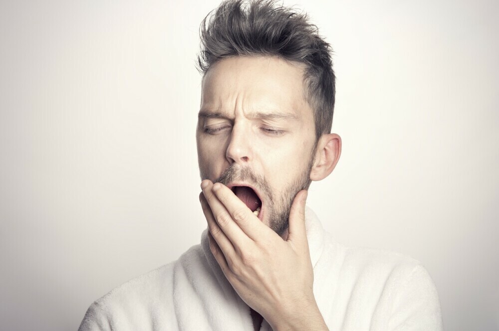 A tired man yawning