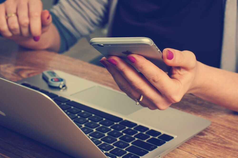 A woman scrolling on her phone instead of working